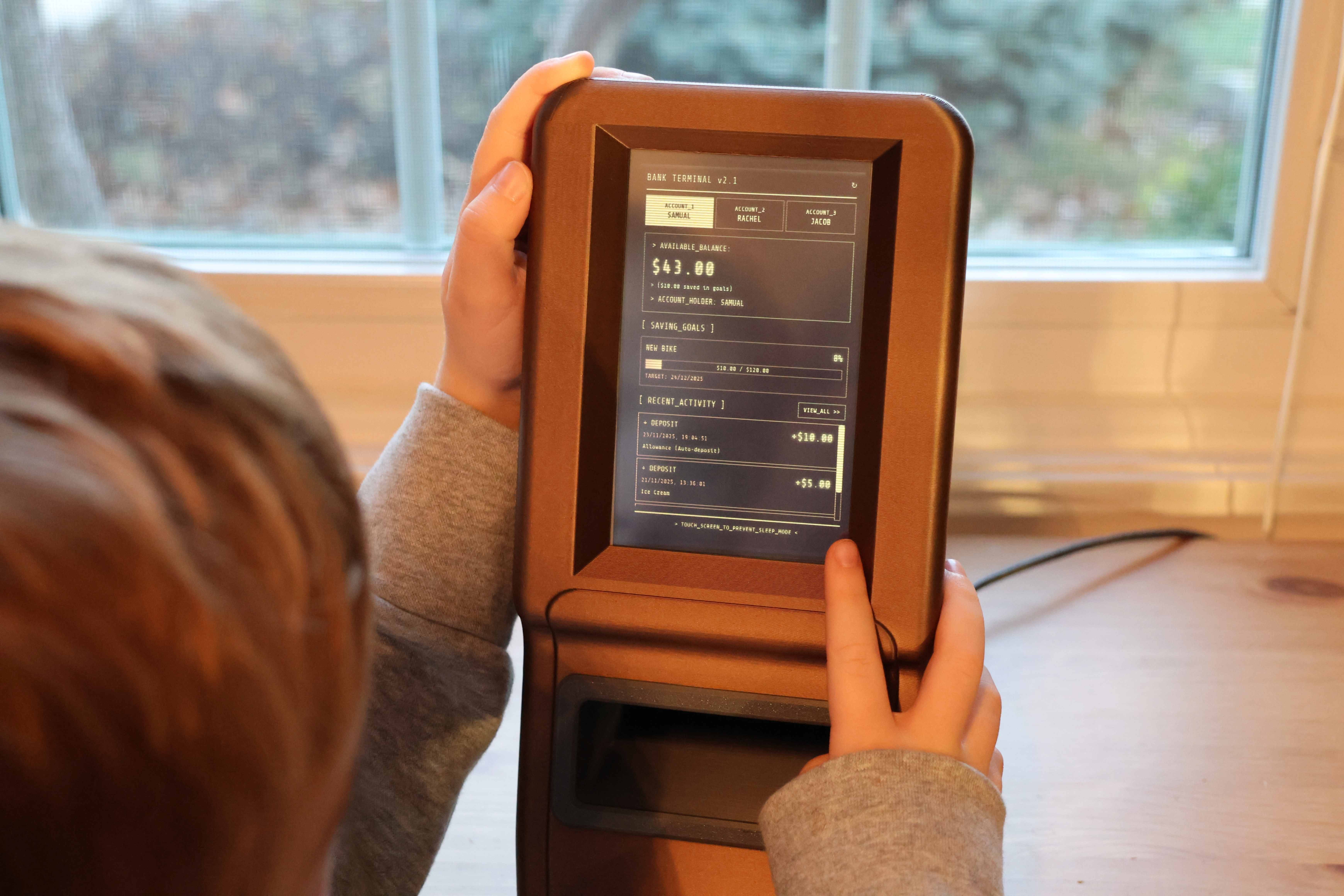 Kid checking balance on VaultQuest kiosk tablet